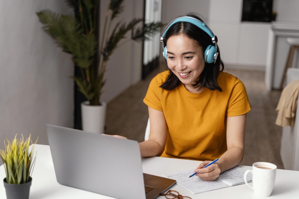 Woman with headphones attending an online class to reach Dutch language level A2.